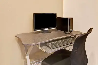 a desk with a computer monitor and a keyboard at Super 8 by Wyndham Longmont/Del Camino in Longmont
