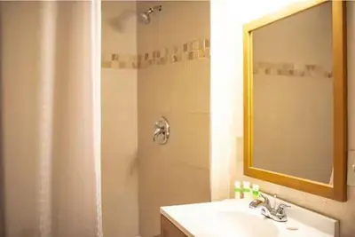 a bathroom with a sink and a shower with a mirror at Alpine Trail Ridge Inn in Estes Park