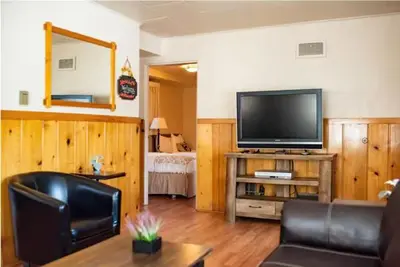 a living room with a flat screen tv and a couch at Alpine Trail Ridge Inn in Estes Park