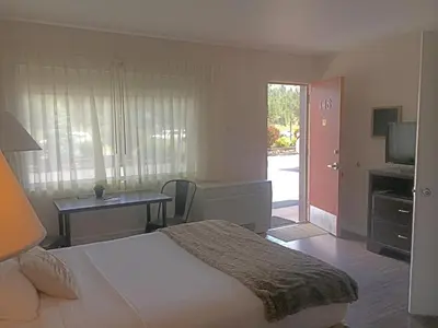 a bedroom with a bed and a table and a door at Alpine Trail Ridge Inn in Estes Park