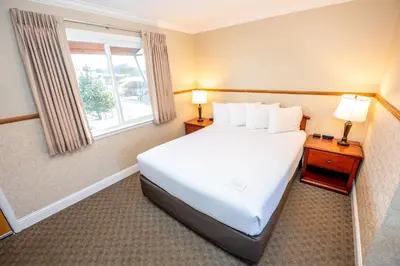 a bedroom with a large white bed and a window at Blue Door Inn in Estes Park