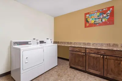 a laundry room with a washing machine and a counter at Travelodge by Wyndham Loveland/Fort Collins Area in Loveland