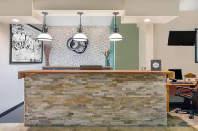 a lobby with a brick counter with pendant lights at Travelodge by Wyndham Loveland/Fort Collins Area in Loveland