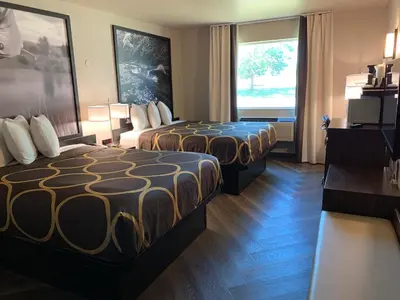 a hotel room with two beds and a window at Super 8 by Wyndham Greeley in Greeley