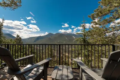 a deck with chairs and a view of mountains at The Cedars Luxury Home At Windcliff Home in Estes Park