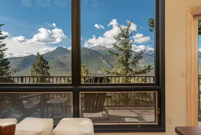 a room with a large window looking out at the mountains at The Cedars Luxury Home At Windcliff Home in Estes Park