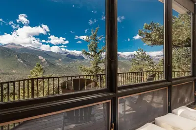 a room with a view of the mountains from a balcony at The Cedars Luxury Home At Windcliff Home in Estes Park