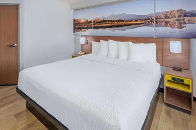 a large white bed in a hotel room at Days Inn & Suites by Wyndham Greeley in Greeley