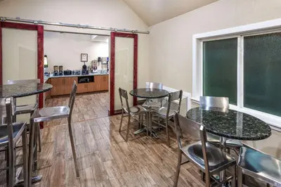 a dining room with tables and chairs and a chalkboard at Days Inn & Suites by Wyndham Greeley in Greeley
