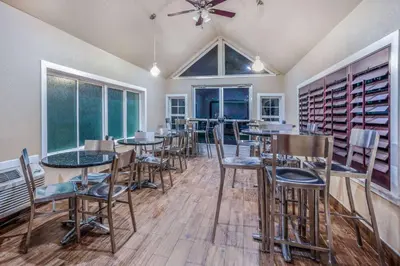 a dining room with tables and chairs and a ceiling fan at Days Inn & Suites by Wyndham Greeley in Greeley