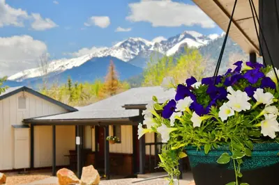 a pot of flowers on a porch with mountains in the background at Murphy's Resort in Estes Park