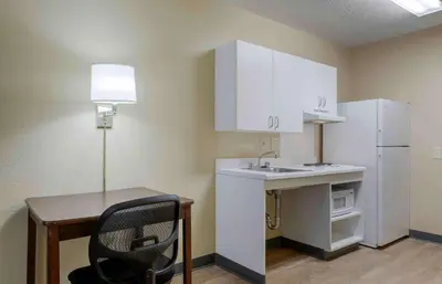 a small kitchen with a desk and a white refrigerator at Extended Stay America Select Suites - Denver - Tech Center South - Greenwood Village in Centennial