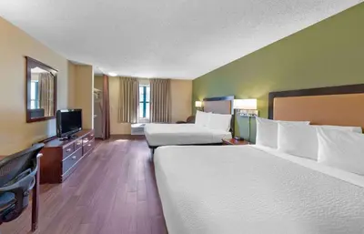 a hotel room with two beds and a flat screen tv at Extended Stay America Select Suites - Denver - Tech Center South - Greenwood Village in Centennial