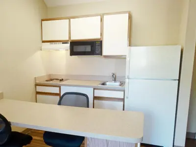 a small kitchen with a refrigerator and a sink at Extended Stay America Select Suites - Denver - Tech Center South - Greenwood Village in Centennial