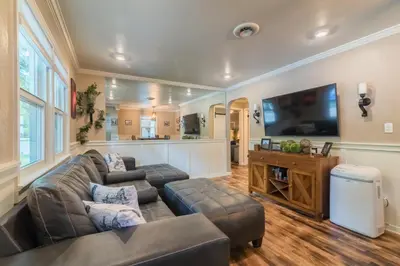 a living room with a couch and a flat screen tv at Italian Style in Old Town with Private Hot Tub in Fort Collins