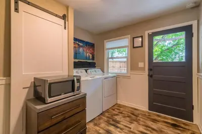 a kitchen with a washer and dryer and a tv at Italian Style in Old Town with Private Hot Tub in Fort Collins