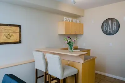 a bar with two chairs and a vase of flowers at Nederland Getaway Home in Nederland