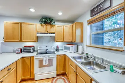 a kitchen with wooden cabinets and white appliances at Aspen Glen 80 in Silverthorne
