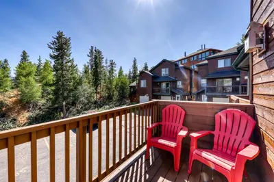 two red chairs sitting on the deck of a house at Aspen Glen 80 in Silverthorne