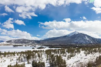 a view of a snowy mountain with trees and a lake at Aspen Glen 80 in Silverthorne