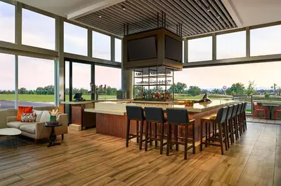 an open kitchen with a bar with chairs and a couch at Hyatt Place Pena Station/Denver Airport in Denver
