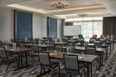 a conference room with tables and chairs and a screen at Hyatt Place Pena Station/Denver Airport in Denver