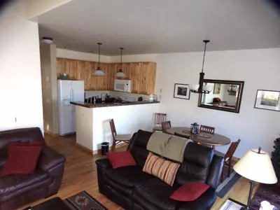 a living room with a couch and a table and a kitchen at Anemone Townhome 3 bed 3 bath HTAT in Silverthorne