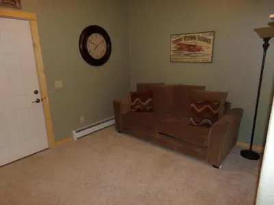 a living room with a couch and a clock on the wall at Anemone Townhome 3 bed 3 bath HTAT in Silverthorne