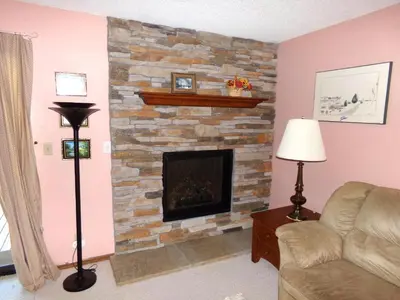 a living room with a stone fireplace at Mountainside 2 Bed 2 Bath MSBD in Frisco
