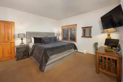 a bedroom with a large bed and a television at Arapahoe Lodge 1 Bed 2 Bath ALJD in Keystone
