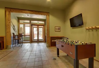a living room with a foosball table and a television at Arapahoe Lodge 1 Bed 2 Bath ALJD in Keystone