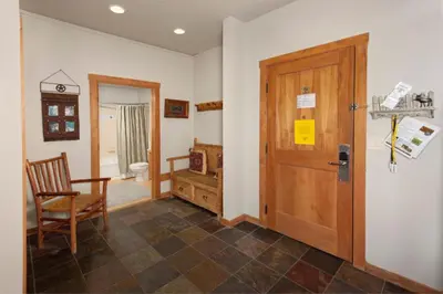 a room with a door and a chair and a toilet at Arapahoe Lodge 1 Bed 2 Bath ALJD in Keystone