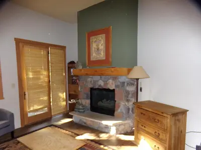 a living room with a stone fireplace and a lamp at Arapahoe Lodge 1 Bed 1 Bath ALJP in Keystone