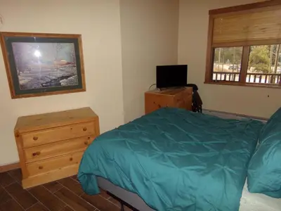 a bedroom with a bed and a dresser and a television at Arapahoe Lodge 1 Bed 1 Bath ALJP in Keystone