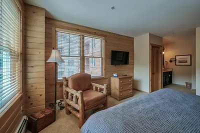 a bedroom with a bed and a chair and a television at Buffalo Lodge 3 Bed 3 Bath BLCD3 in Keystone