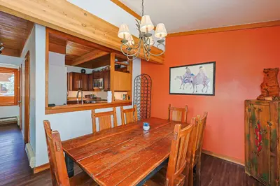 a kitchen and dining room with a wooden table and chairs at Tennis Townhome 2 Bd 25 Ba TTMR in Keystone
