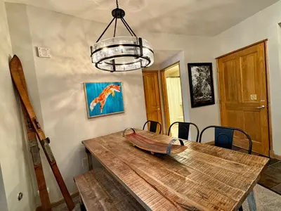 a dining room with a wooden table with a bowl on it at Jack Pine 8005 by SummitCove Lodging in Keystone
