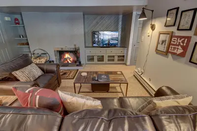 a living room with a couch and a fireplace at Wild Irishman 1059 by SummitCove Lodging in Keystone