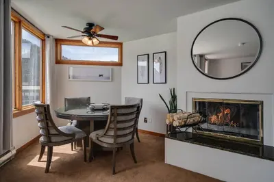 a dining room with a table and a fireplace at Lakeside 1481 by SummitCove Lodging in Keystone