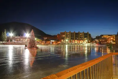a christmas tree in a parking lot at night at Lakeside 1481 by SummitCove Lodging in Keystone