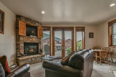 a living room with a leather couch and a fireplace at Antlers Gulch 501 by SummitCove Lodging in Keystone