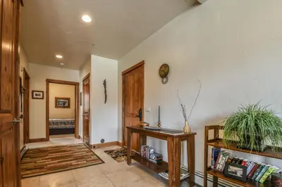 a living room with a table and a hallway at Antlers Gulch 501 by SummitCove Lodging in Keystone