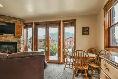 a living room with a table and chairs and a fireplace at Antlers Gulch 501 by SummitCove Lodging in Keystone