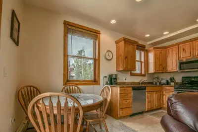 a kitchen with a table and chairs and a sink at Antlers Gulch 501 by SummitCove Lodging in Keystone