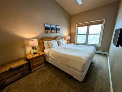 a bedroom with a large bed and a window at Hidden River Lodge 5981 by SummitCove Lodging in Keystone
