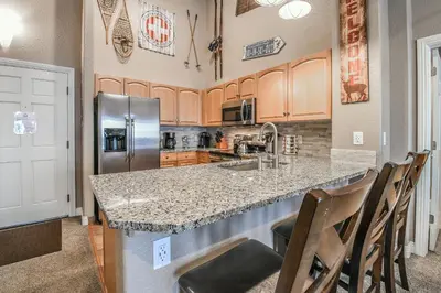 a kitchen with a granite counter top and stainless steel appliances at Hidden River Lodge 5981 by SummitCove Lodging in Keystone