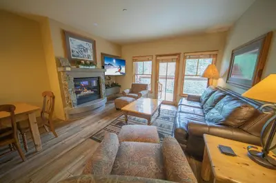 a living room with a couch and a fireplace at Jack Pine 8006 by SummitCove Lodging in Keystone
