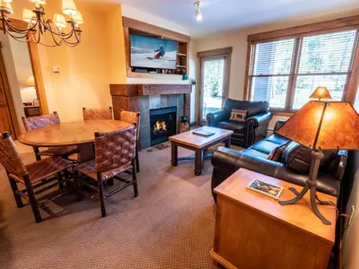 a living room with a couch and a table and a fireplace at Springs 8805 by SummitCove Lodging in Keystone