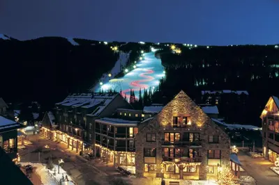 a resort with a river in the background at night at Seasons 1850 in Keystone