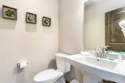 a white bathroom with a toilet and a sink at Treehouse Village 323 in Silverthorne